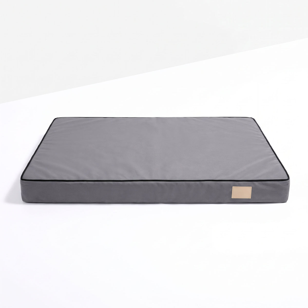 Flat foam dog bed mattress with grey Oxford cover, black piped border and beige front tag