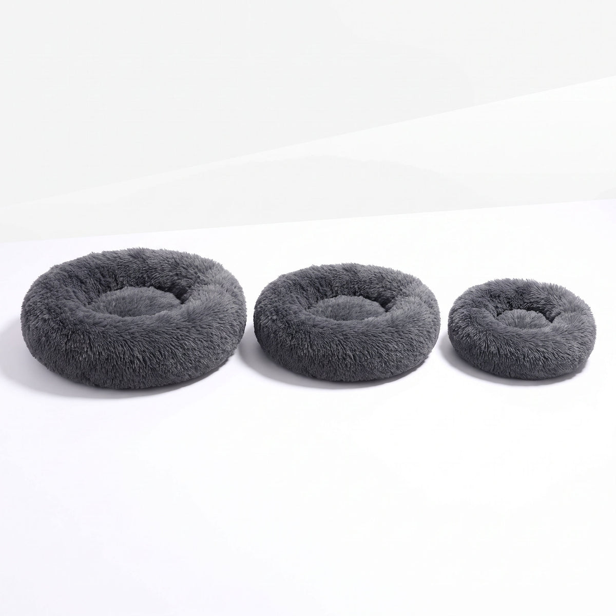 Three sizes of the round plush cat bed shown together to compare diameters