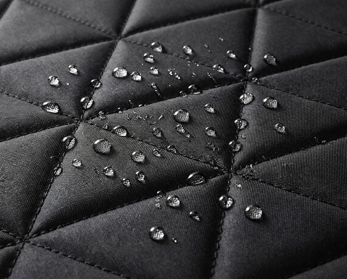 Water droplets beading on the quilted diamond-stitch surface