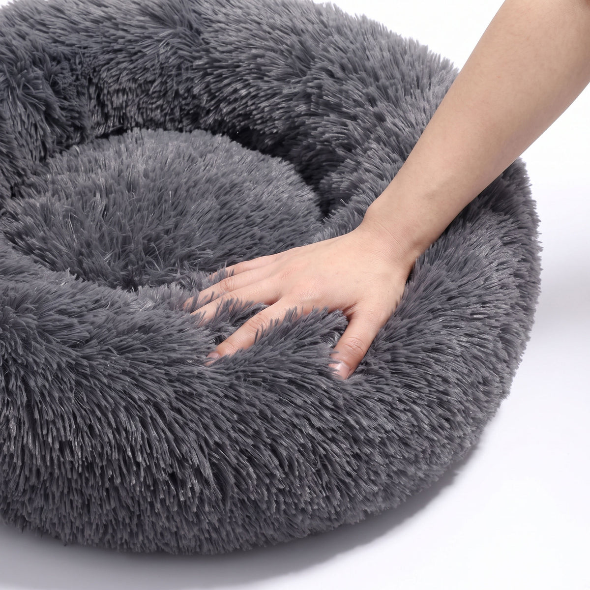 A woman's hand pressing into the raised plush edge to show its give